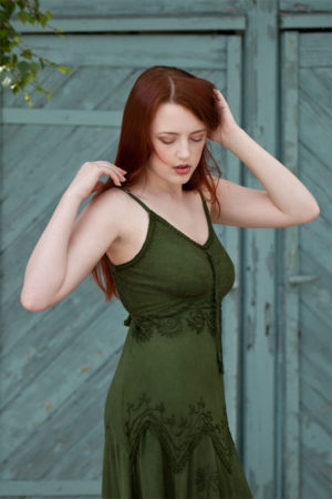 Outdoor natural light photograph of a woman in her twenties wearing a green dress